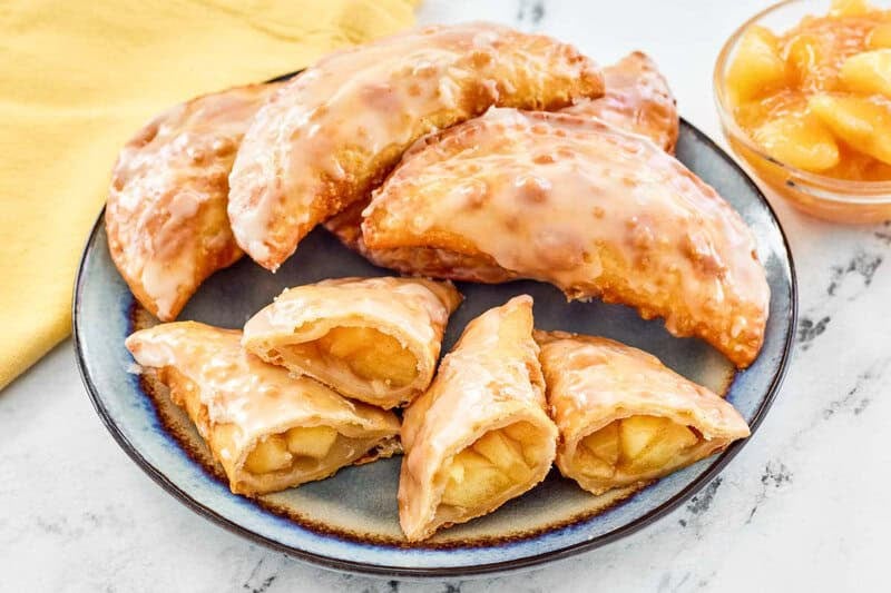 Copycat Taco Bell caramel apple empanadas and a bowl of caramel apple filling.