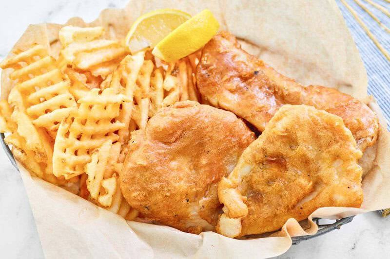 Copycat Long John Silver's batter fried fish and fries in a parchment paper lined basket.