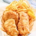 Copycat Long John Silver's batter fried fish, lemon wedges, and fries in a basket.