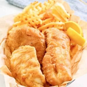 Copycat Long John Silver's batter fried fish, lemon wedges, and fries in a basket.