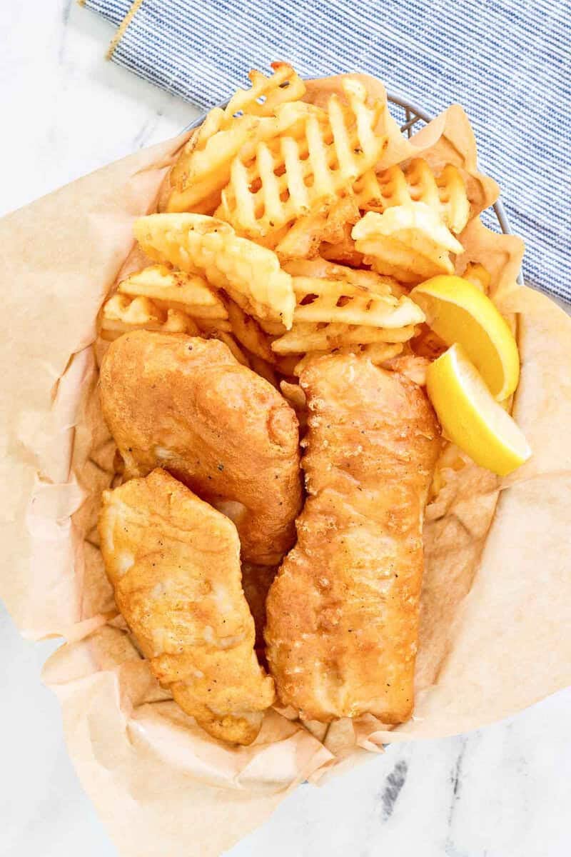 Copycat Long John Silver's batter fried fish and waffle fries in a wire basket.