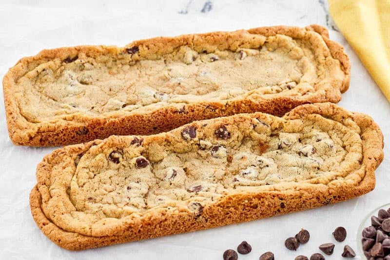 Copycat Subway chocolate chip footlong cookies and chocolate chips in front of them.