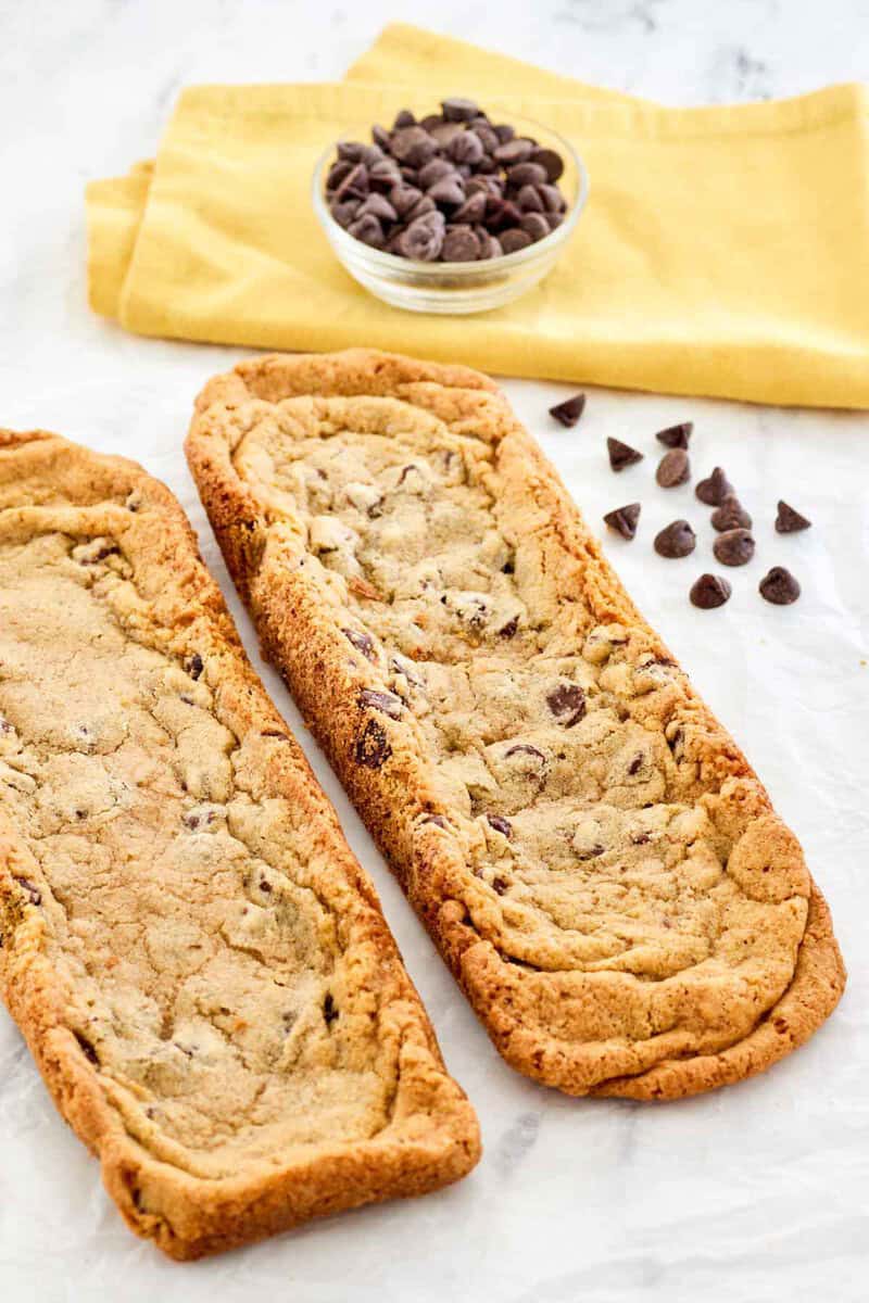 Copycat Subway chocolate chip footlong cookies and a bowl of chocolate chips.