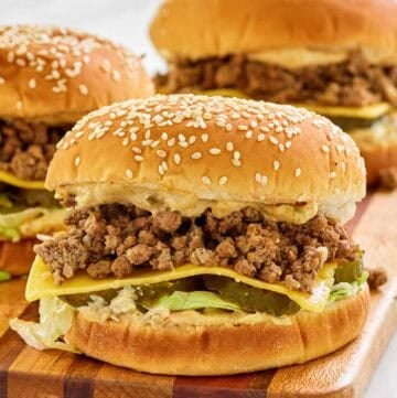 Big mac sloppy joes on a wood cutting board.