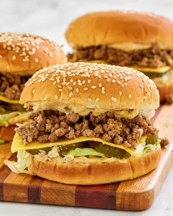 Big mac sloppy joes on a wood cutting board.