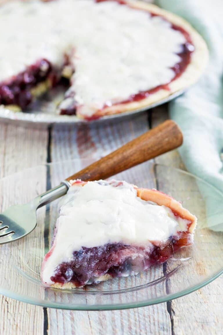 Copycat Marie Callender's sour cream blueberry pie and a slice on a plate.