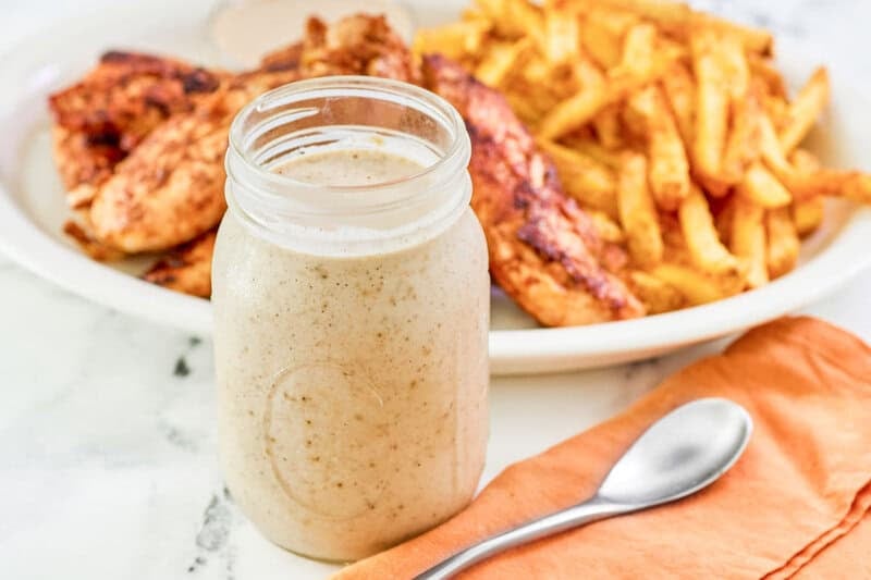 Copycat Popeyes blackened ranch in a mason jar and a spoon next to it.