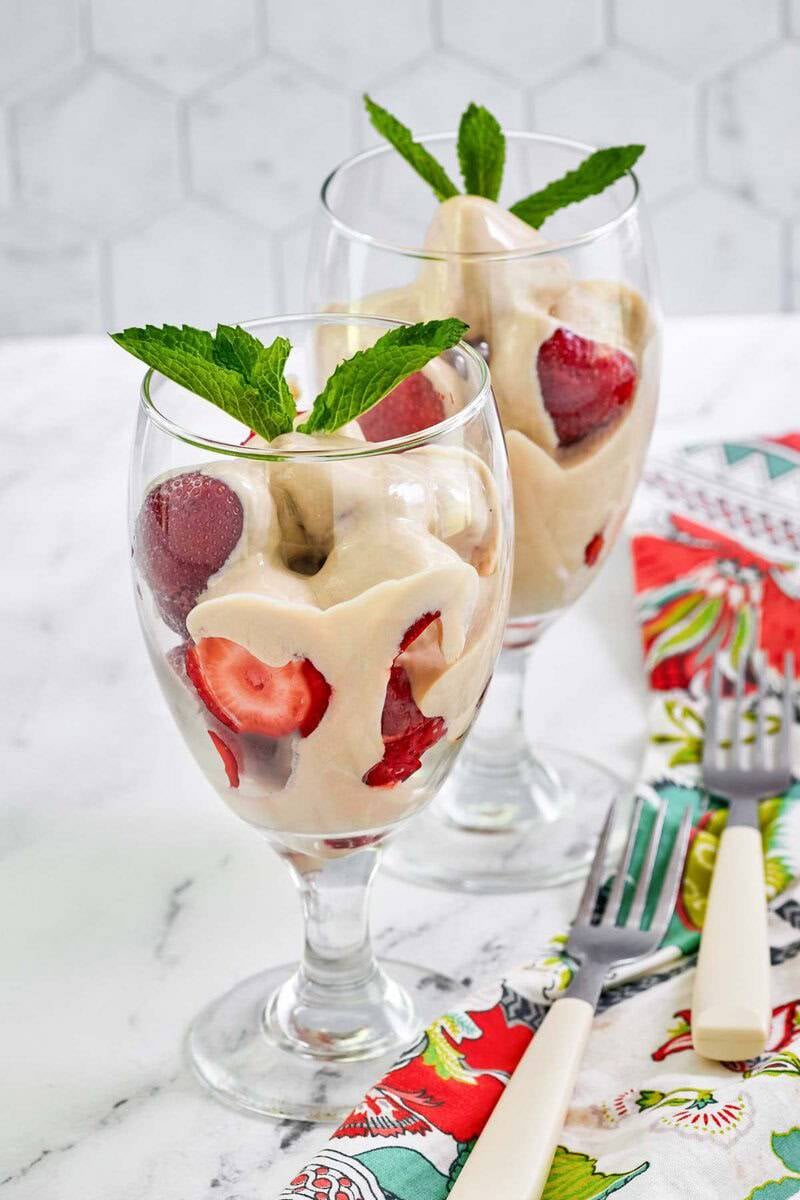 Copycat La Madeleine strawberries romanoff dessert in two stem wine glasses.