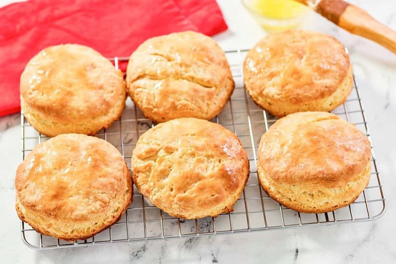 Six copycat Bojangles buttermilk biscuits on a wire rack.