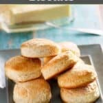 Homemade Cracker Barrel biscuits on a plate and butter behind it.