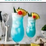 Two homemade Olive Garden Blue Hawaiian cocktails in hurricane glasses.