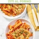 Two plates of homemade Olive Garden five cheese ziti al forno and two forks on a napkin.