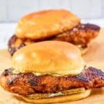Copycat Popeyes blackened chicken sandwiches with mayo and pickles.