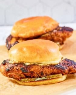 Copycat Popeyes blackened chicken sandwiches with mayo and pickles.