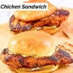 Two homemade Popeyes blackened chicken sandwiches on a marble surface.