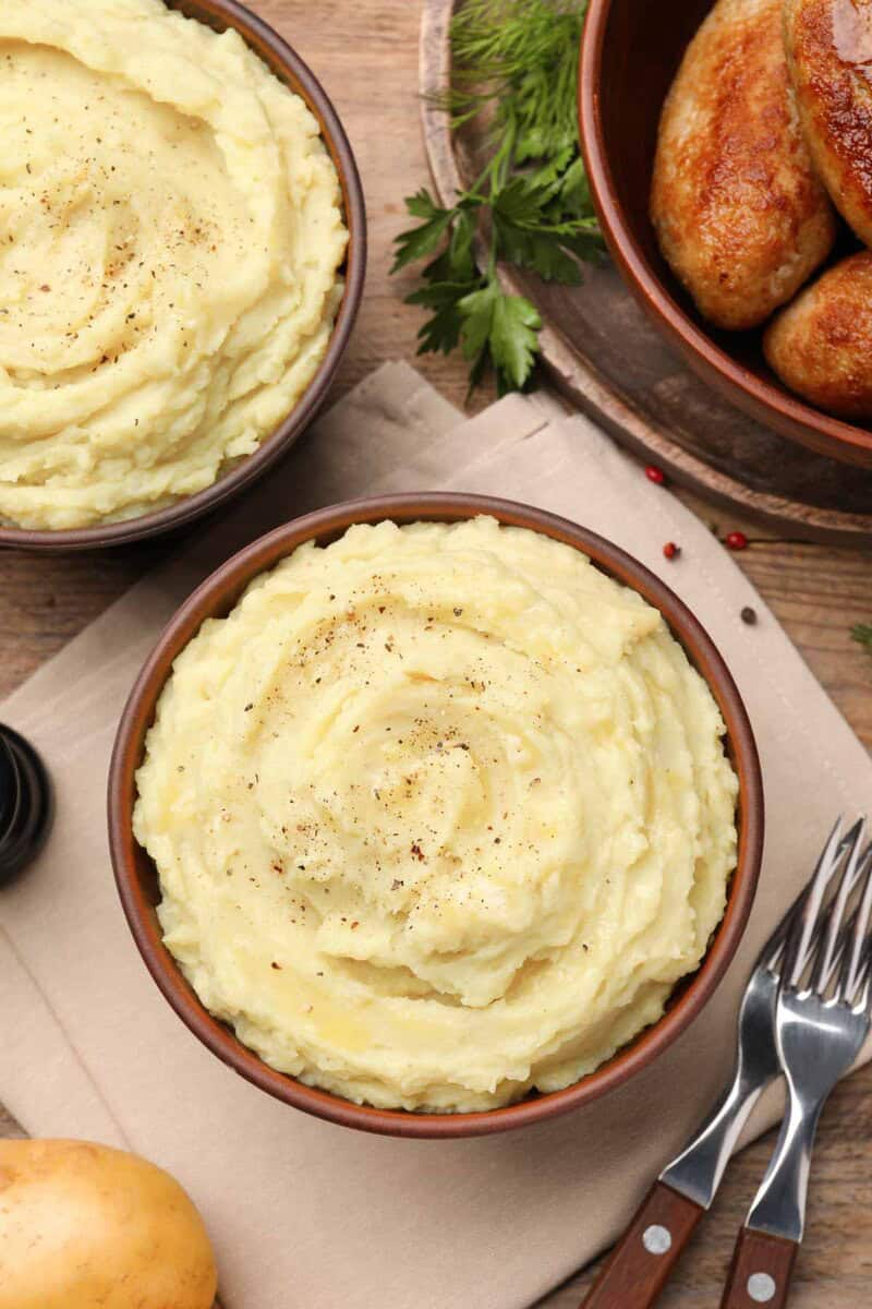 Two bowls of homemade simple mashed potatoes.