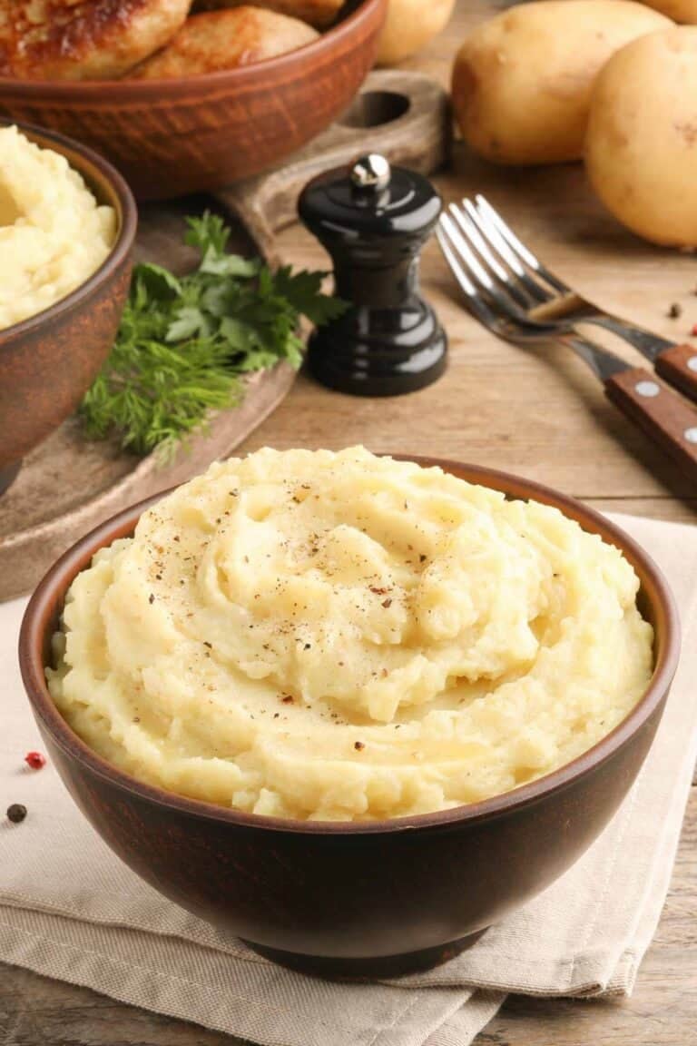 Homemade simple mashed potatoes, forks, and a pepper grinder.