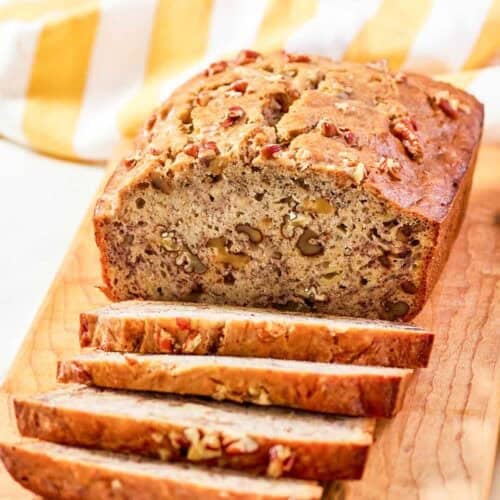 Copycat Starbucks banana walnut and pecan bread loaf on a wood board.
