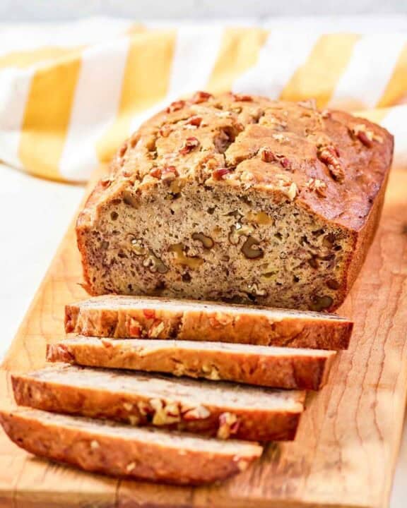 Copycat Starbucks banana walnut and pecan bread loaf on a wood board.