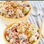 Homemade chicken salad chick grape salad in two bowls and two spoons next to them.