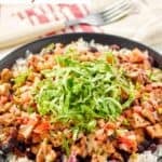 A bowl of homemade Chipotle honey chicken, beans, and pico de gallo over rice.