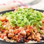 A rice bowl with homemade Chipotle honey chicken, beans, pico de gallo, and lettuce.