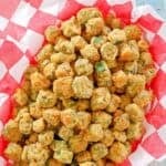Southern fried okra on parchment paper in a serving basket.