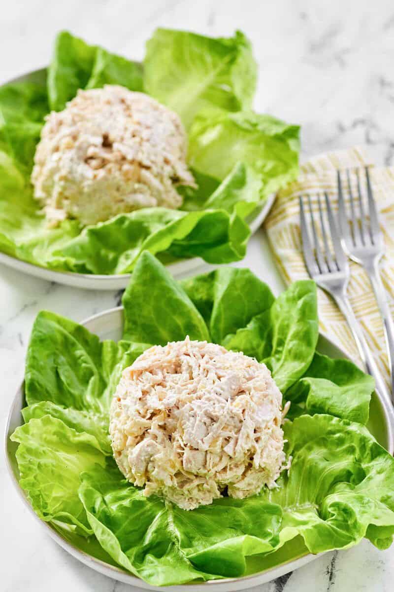 Copycat Jason's Deli chicken salad on lettuce on two plates and two forks by them.
