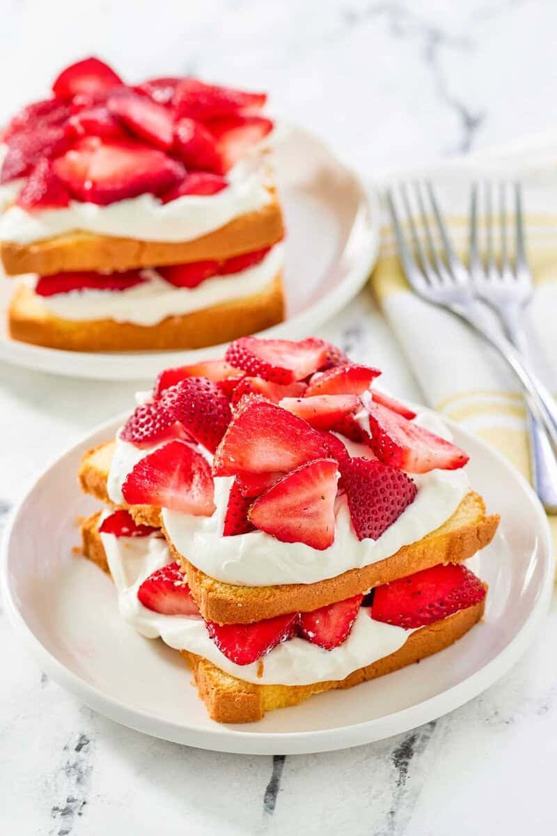 Copycat Jason's Deli strawberry shortcake dessert on two plates and two forks next to them.