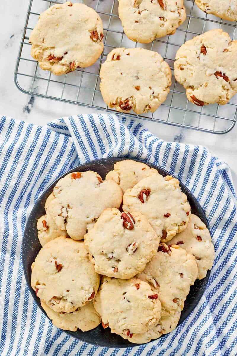 Copycat Keebler pecan sandies cookies on a wire rack and plate.