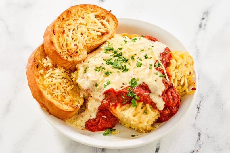 Copycat Marie Callender's garlic toast in a bowl with lasagna.