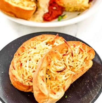 Slices of copycat Marie Callender's garlic toast on a plate and with lasagna.