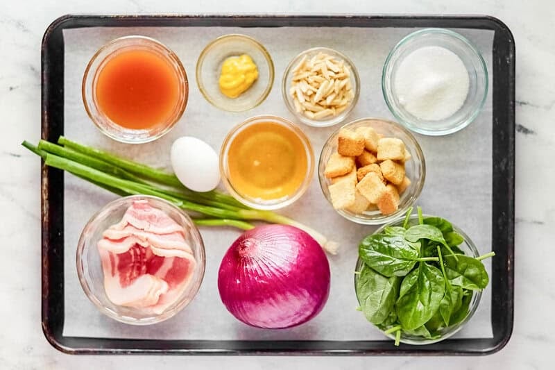 Copycat Simon and Seafort's mustard dressing and salad ingredients on a tray.
