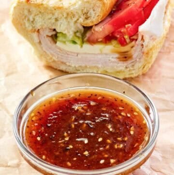 A bowl of copycat Subway sweet onion teriyaki sauce and a sub sandwich.