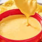 Copycat Taco Bell nacho cheese and a tortilla chip dipped in the sauce.