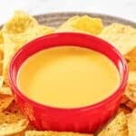 Homemade Taco Bell nacho cheese sauce and tortilla chips on a platter.