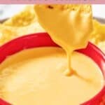 Homemade Taco Bell nacho cheese and a tortilla chip dipped in the sauce.