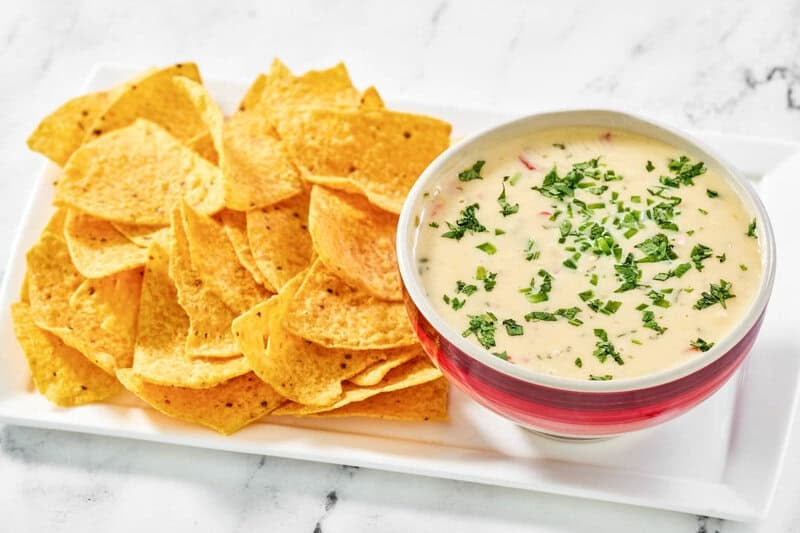 Copycat Applebee's queso blanco in a bowl and tortilla chips next to it.