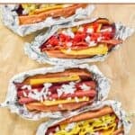 Four homemade Five Guys hot dogs with assorted toppings.