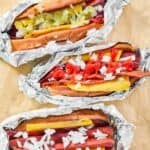 Four homemade Five Guys hot dogs on parchment paper.