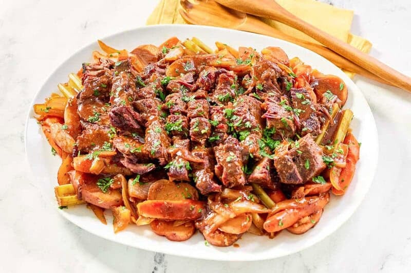 Copycat golden corral pot roast, vegetables, and gravy on a platter.