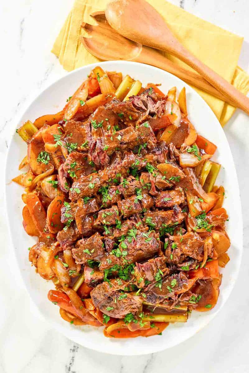 Copycat golden corral pot roast with gravy and vegetables on a platter.