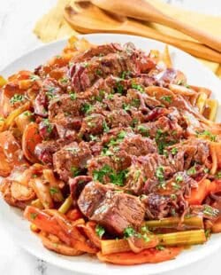 Copycat golden corral pot roast with vegetables and gravy on a platter.
