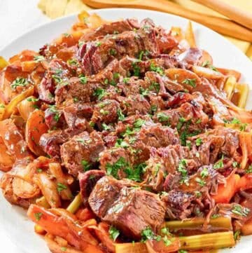 Copycat golden corral pot roast with vegetables and gravy on a platter.
