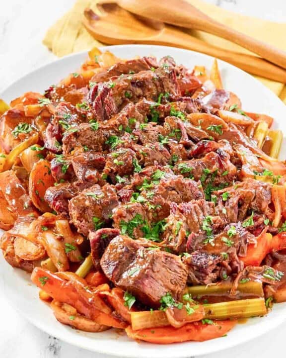 Copycat golden corral pot roast with vegetables and gravy on a platter.