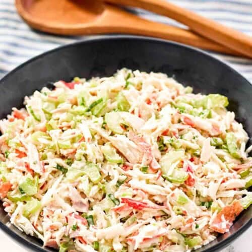 Copycat Golden Corral seafood salad in a large bowl and salad tongs behind it.