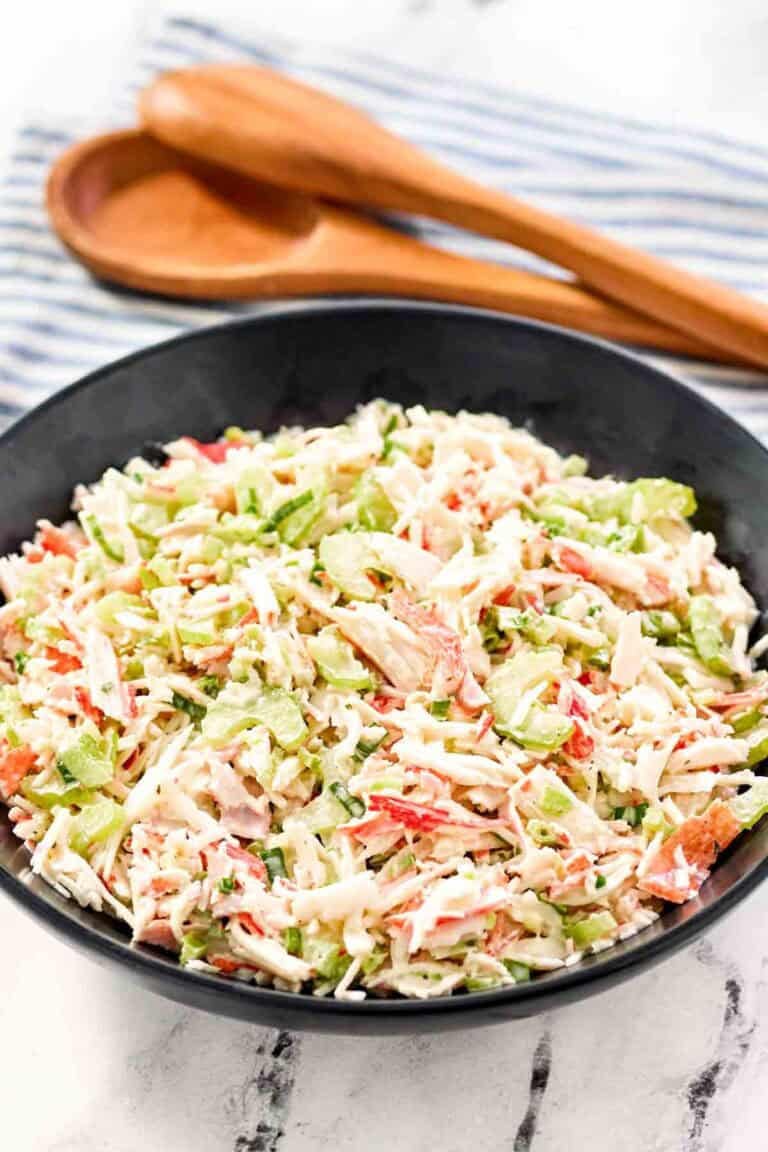 Copycat Golden Corral seafood salad in a large bowl and salad tongs behind it.