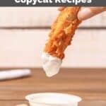 Dipping a chicken tender into buttermilk ranch sauce.