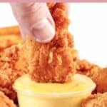 Dipping a fried chicken tender into honey mustard sauce.