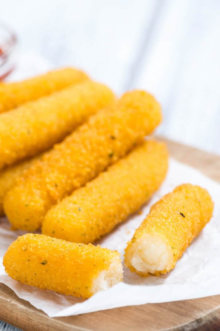 Smoked mozzarella cheese sticks on a wood board.